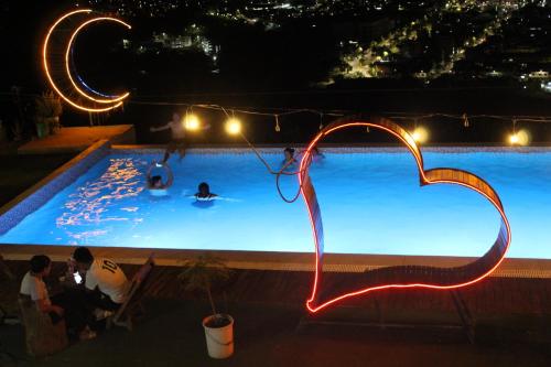 Una piscina de noche con gente en el agua. en Hostal Fioris, en Quillabamba