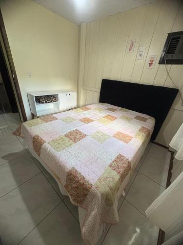 a bedroom with a bed with a quilt on it at Pousada Paraíso Central - Casa Branca in Rodeio