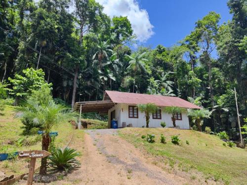a small house in the middle of a dirt road at Pousada Paraíso Central - Casa Branca in Rodeio