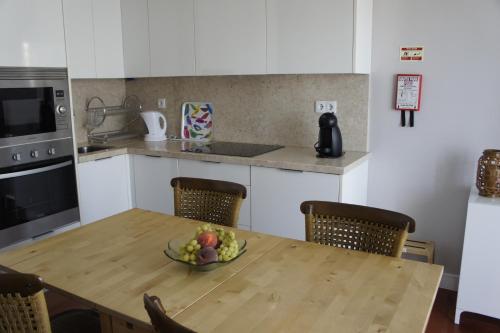 a kitchen with a wooden table with a bowl of fruit on it at Apartamento Monte Estoril in Cascais