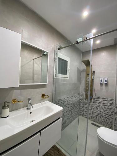 a bathroom with a sink and a glass shower at KSyiimmo Signature aéroport Marrakech in Marrakesh