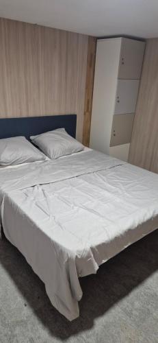 1 cama blanca grande con cabecero azul en una habitación en Rué de Rome, en Lucé