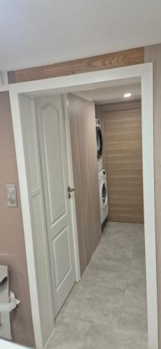 Una puerta que conduce a un lavadero con lavadora. en Rué de Rome, en Lucé