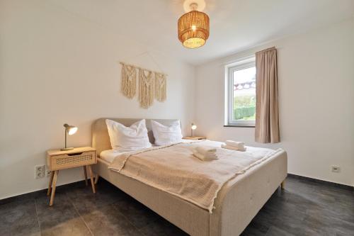 a bedroom with a large bed and a window at Charmantes Ferienhaus an der Mosel mit Garten, Weinbergblick & Privatparkplatz in Zeltingen-Rachtig