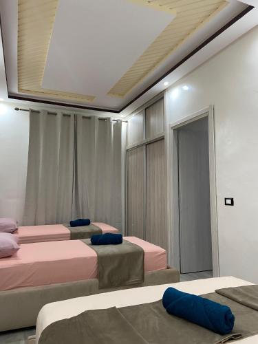a room with three beds and a ceiling at KSyiimmo Signature aéroport Marrakech in Marrakesh