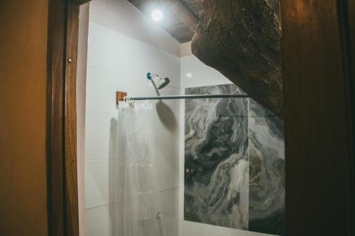 una ducha con cortina de ducha en un baño en Hostal Rosa Mística, en Montañita