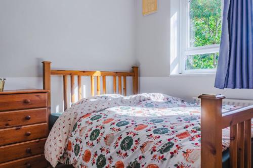 ロンドンにあるCozy 4-Bed House in Wimbledonのベッドとドレッサーと窓のある寝室