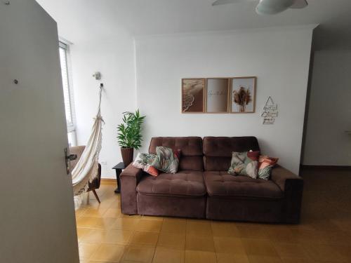 a brown couch sitting in a living room at 2U TOUR - Guarujá perfeito in Guarujá