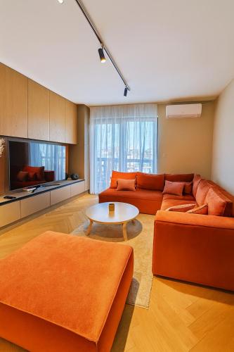 a living room with two orange couches and a table at Apartmán MONTARA in Donovaly