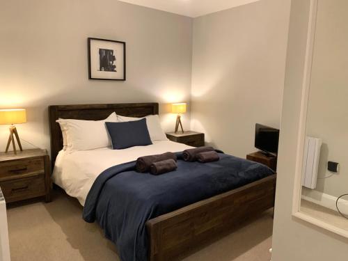a bedroom with a bed with two brown towels on it at 89a Church Street - Luxury One Bed Apartment with Roof Terrace in Whitby