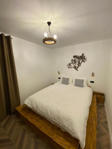 1 dormitorio con 1 cama grande con sábanas blancas y techo en EleS Chalet, en Brebu