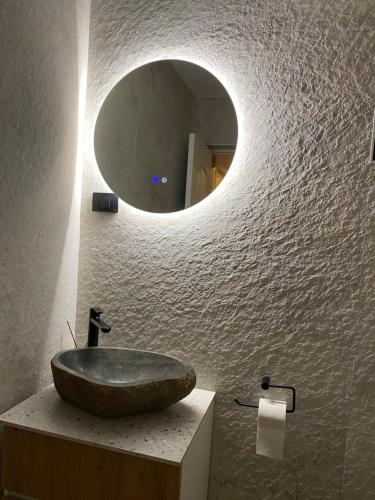 ein Badezimmer mit Steinwaschbecken und Spiegel in der Unterkunft EleS Chalet in Brebu