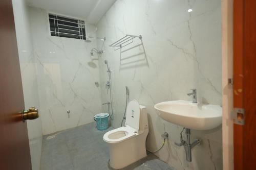a bathroom with a toilet and a sink at The Royal Pavilion Hotel in Kanipakam