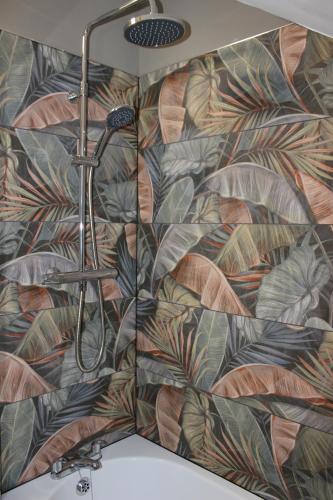 een douchecabine in een badkamer met bloemenbehang bij Blackburn Heights Sleeps 4 Family Apartment in Bridlington