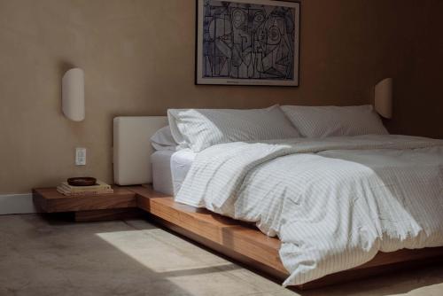 a bedroom with a large white bed with a wooden platform at Mane & Saddle Loft in Los Angeles