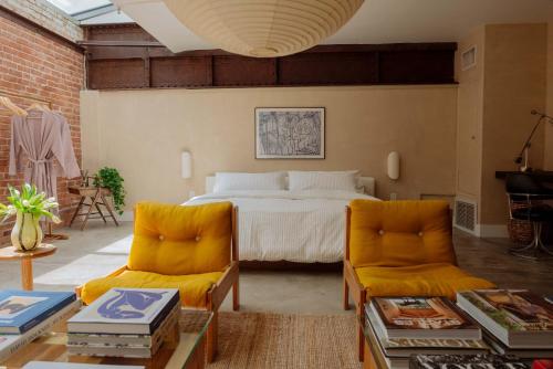 a bedroom with a bed and two chairs at Mane & Saddle Loft in Los Angeles