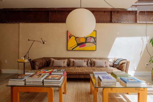 a living room with a couch and two tables with books at Mane & Saddle Loft in Los Angeles