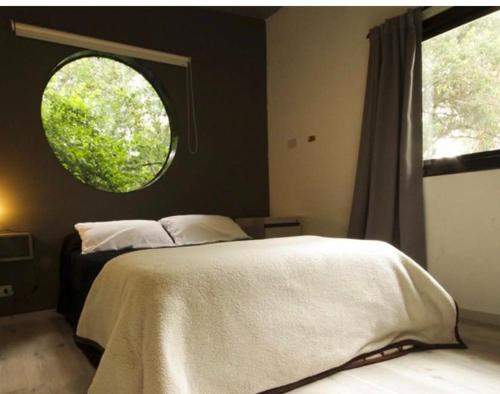 a bedroom with a large bed with a round window at Vida en el bosque in Necochea