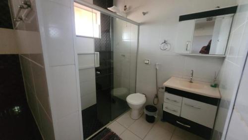ein Badezimmer mit Dusche, Toilette und Waschbecken in der Unterkunft Chacara vale do igapó bauru in Bauru