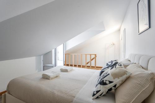 Un dormitorio blanco con una cama con toallas. en Casa dos Barrett, en Lisboa
