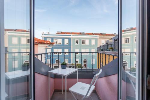 a balcony with a table and a chair at Casa dos Barrett in Lisbon