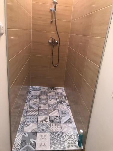 a bathroom with a shower with a tile floor at Krāģīši - Quiet Countryside aura in Rencēni
