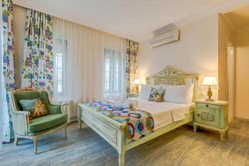 a bedroom with a bed and a chair at Cunda Esen Hotel in Ayvalık