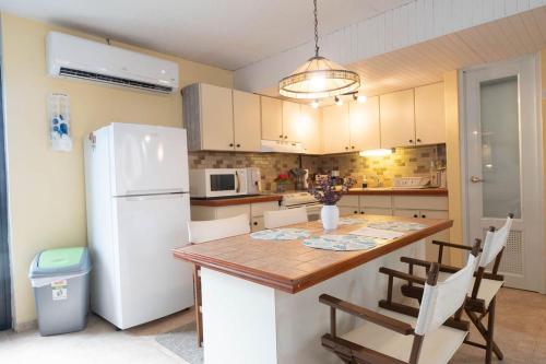 a kitchen with a white refrigerator and a table and chairs at BeachBums Hideaway in Luquillo