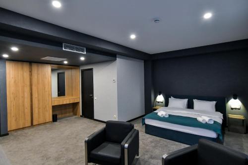 a hotel room with a bed and a chair at The West Inn-Georgia Hotel in Kutaisi