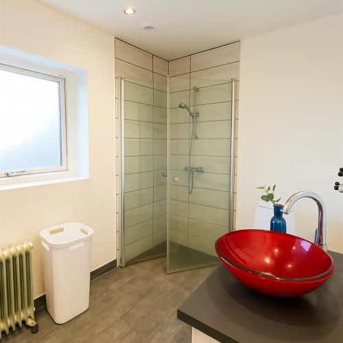 a bathroom with a red bowl sink and a shower at Aarhus Stay Apartments in Hasselager