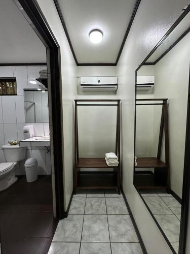 a bathroom with a toilet and a sink and a mirror at Brillasol Airport Hotel in Alajuela