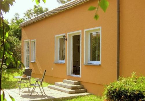 a small orange house with a table and a patio at Das-Atelier in Lohme