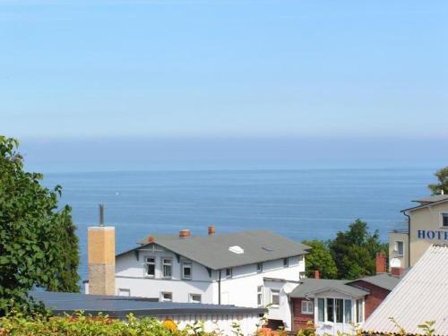 a white house with the ocean in the background at Ruhe-Natur-Meerblick-Das-Atelier-in-Lohme-Wandern-Radfahren-Golf-direkt-vor-der-Tuer in Lohme