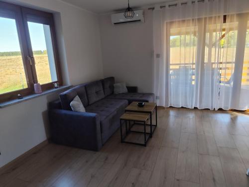 a living room with a couch and a table at Modrzewiowy Zakątek in Ołobok