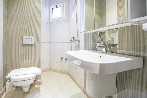 a white bathroom with a sink and a toilet at Mabaat-White Pearl Compound 600 B Villa 16 in Jeddah