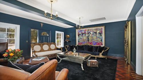a living room with blue walls and leather furniture at Southern Grace in Bowral