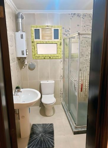 a bathroom with a toilet and a sink and a shower at 2Bedroom Apartment and Living Room at Shiekh Zayed in Sheikh Zayed