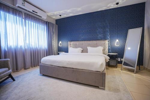 een slaapkamer met een groot bed en een blauwe muur bij Mabaat-White Pearl Compound 600 B Villa 3 in Jeddah