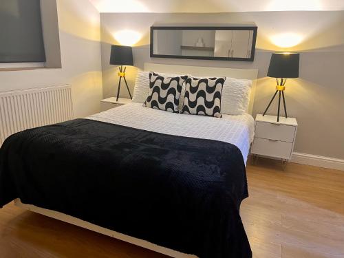 a bedroom with a black and white bed and two lamps at New Modern 3 Bed En-suites City Centre Apartment - Sleeps 8- Paid Parking Options in Preston