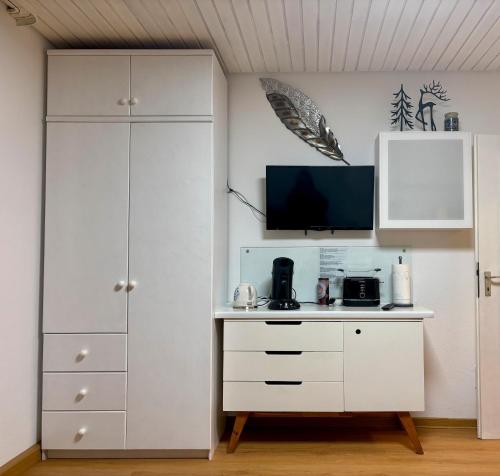 a room with a white cabinet and a tv at Ferienwohnung Riese in Triberg