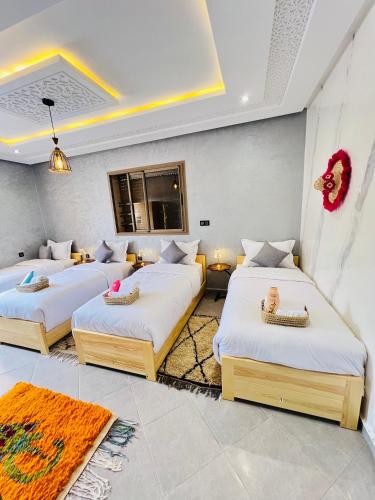 a room with three beds in a room at Tadinga Surf House in Imsouane