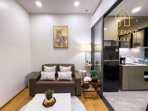 a living room with a couch and a kitchen at City Luxe Condo 5-Min Walk to Siam Paragon Modern Stay in Bangkok