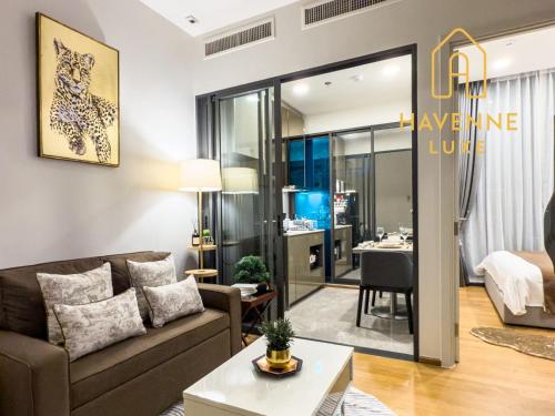 a living room with a couch and a table at City Luxe Condo 5-Min Walk to Siam Paragon Modern Stay in Pratunam