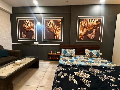een slaapkamer met een bed en drie schilderijen aan de muur bij Bell Rooms Luxury studio Apartment in Noida