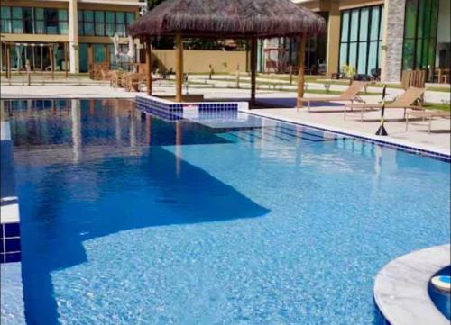 a large swimming pool with a gazebo and blue water at Casa Milagres Morada do toque- By milagres hospitalidade in São Miguel dos Milagres