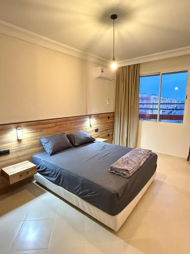 a bedroom with a large bed and a large window at Cosy apartment near Marrakech Airport in Marrakech