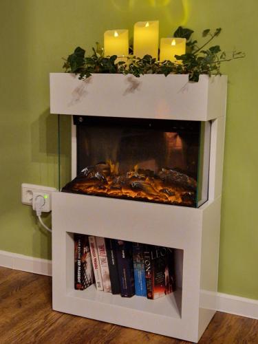 a white fireplace with two candles and books at Apartment Piepmäker mit Parkplatz und Kamin, Bahnhof fußläufig in Goslar