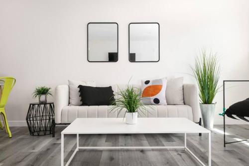 a living room with a white couch and two mirrors at Central 3BR Apt Near Americana in Glendale
