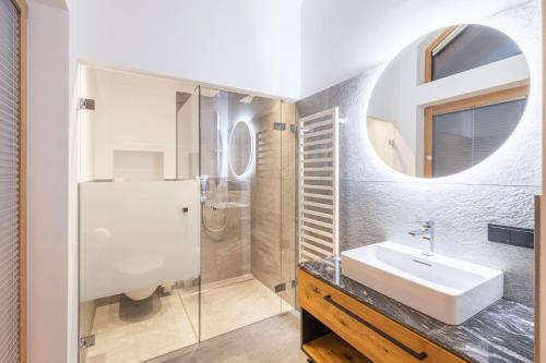a bathroom with a sink and a shower and a mirror at Ferienlodge Edelstein in Forstau