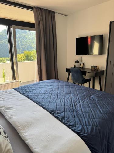 a hotel room with a bed and a desk and a window at Schöne Aussicht - charmante Ferienwohnung mit Pool und Sauna in Bad Harzburg in Bad Harzburg